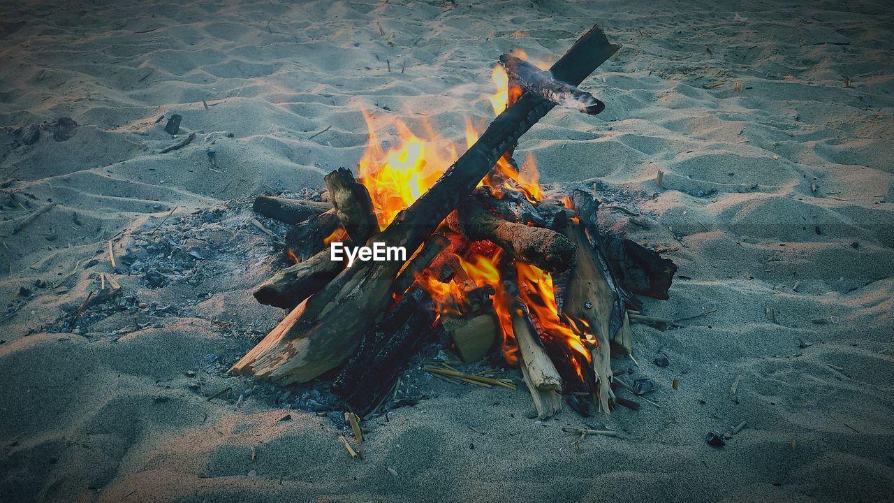 High angle view of bonfire on beach during sunset