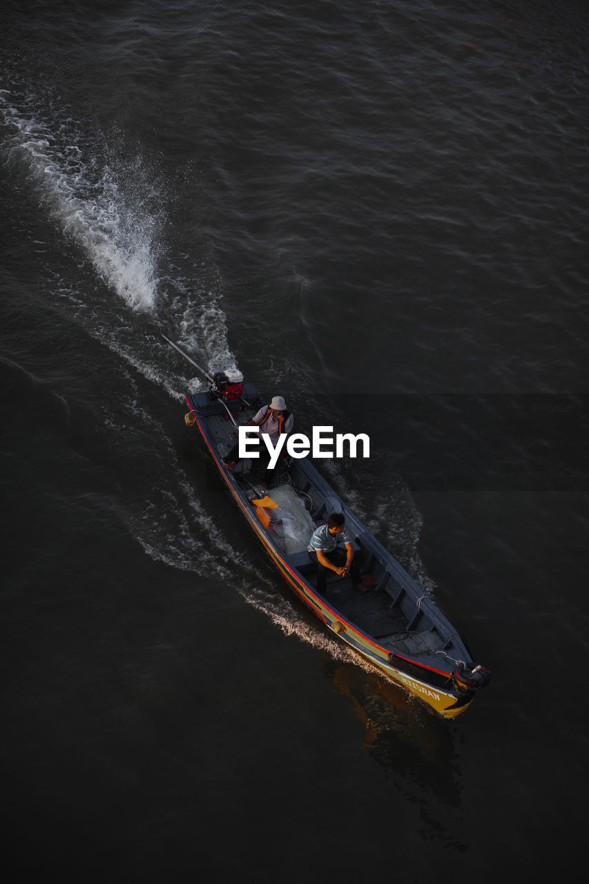 HIGH ANGLE VIEW OF PEOPLE SAILING SHIP IN SEA