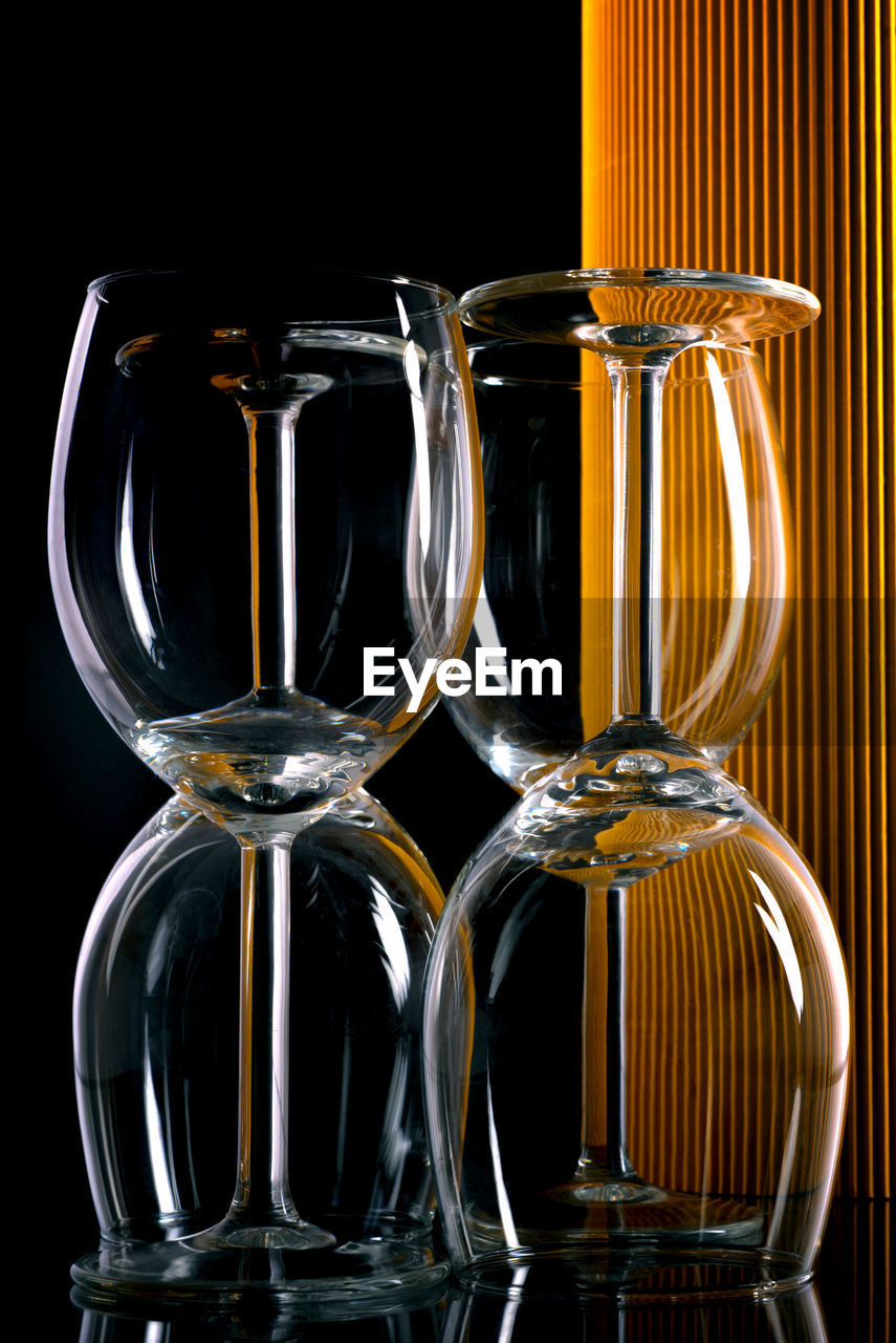 Close-up of drinking glasses on table against black background