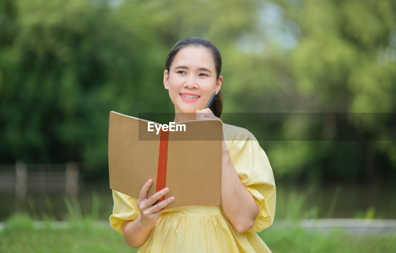 PORTRAIT OF HAPPY GIRL HOLDING BOOK