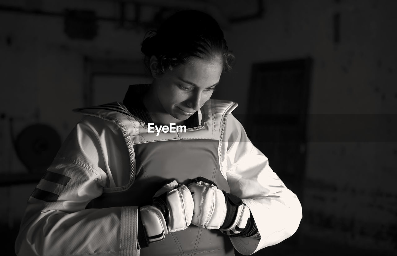 Female taekwondo artist holding helmet