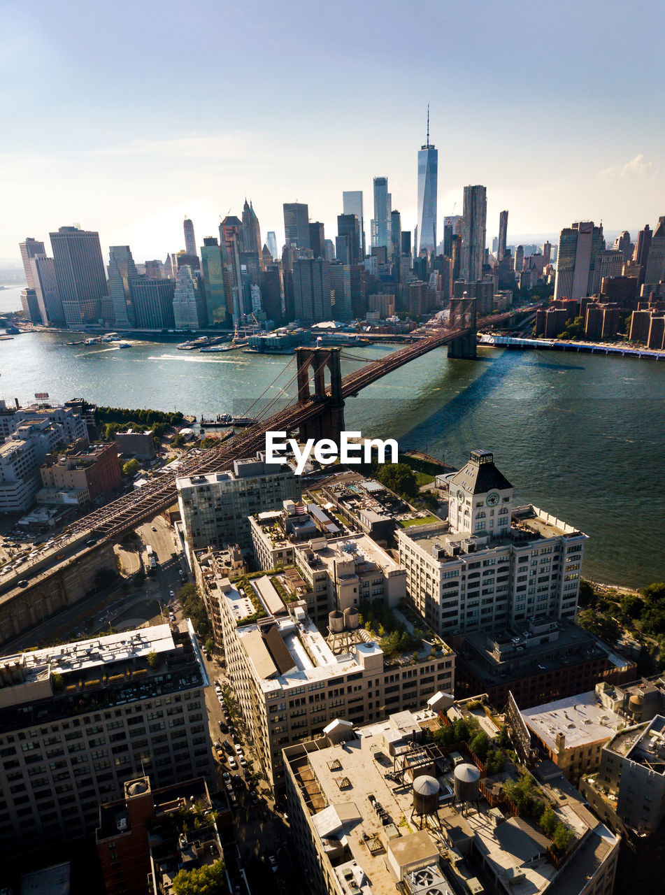 Aerial view of brooklyn bridge over river in city against sky