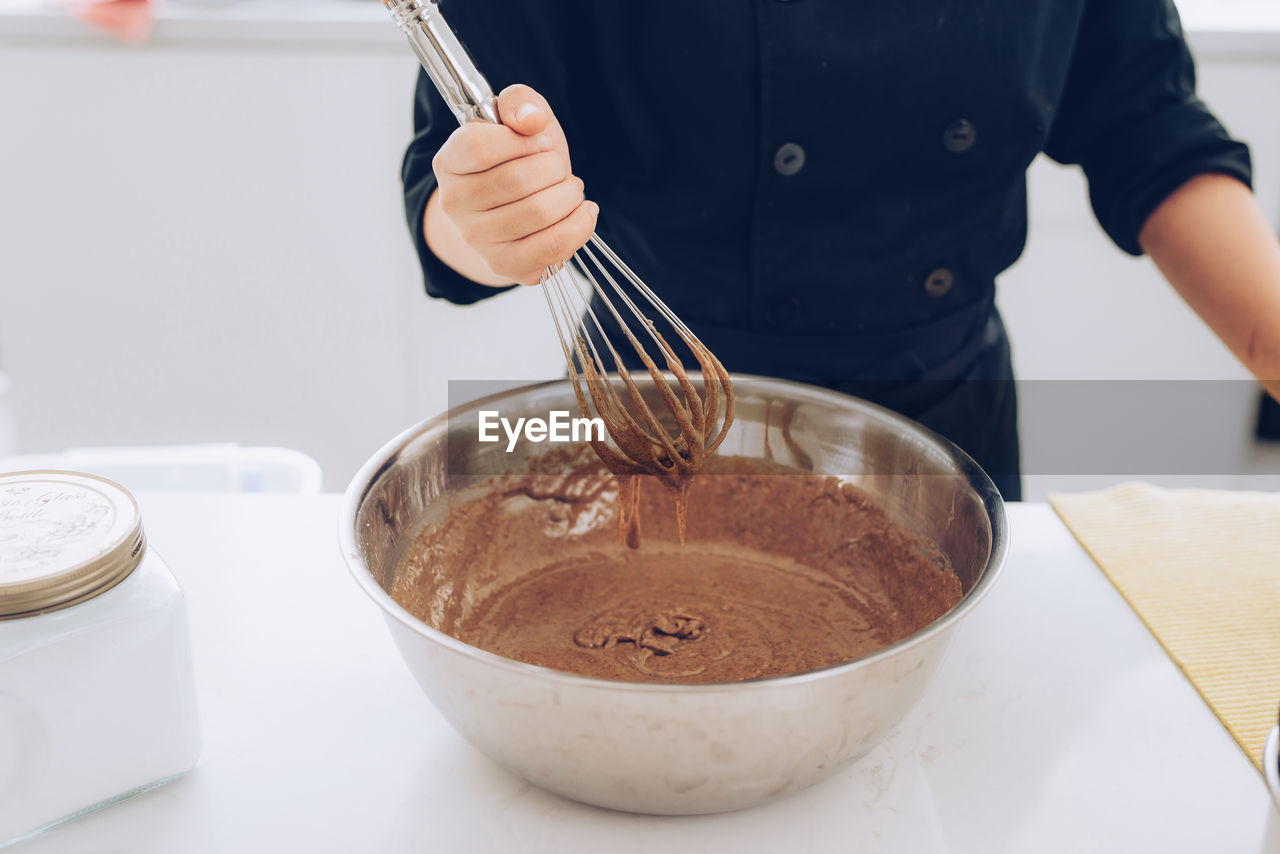 Midsection of woman preparing sweet food in kitchen