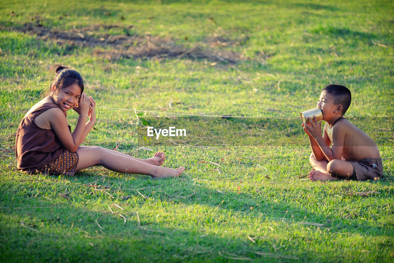 Siblings playing on field