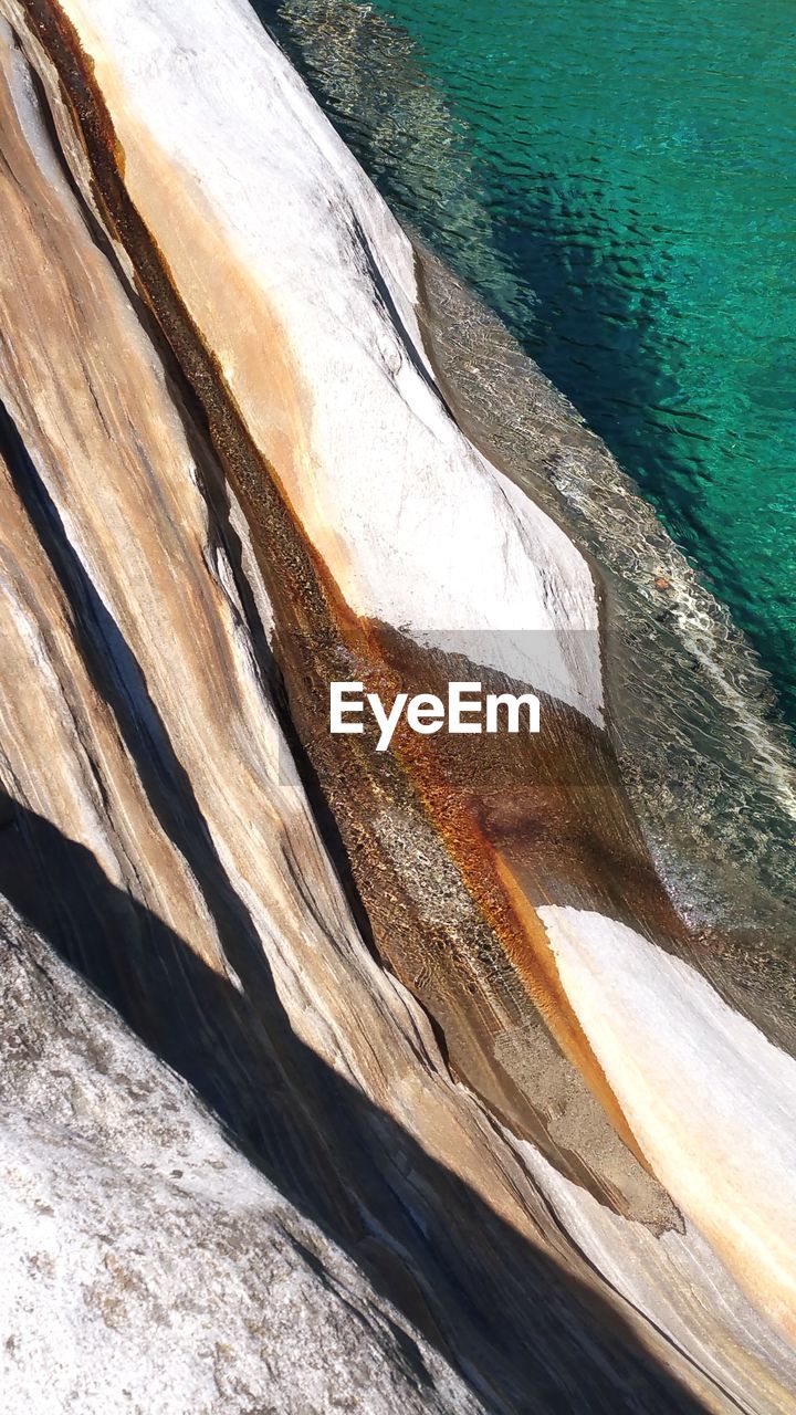 HIGH ANGLE VIEW OF ROCK FORMATION AT SEA SHORE