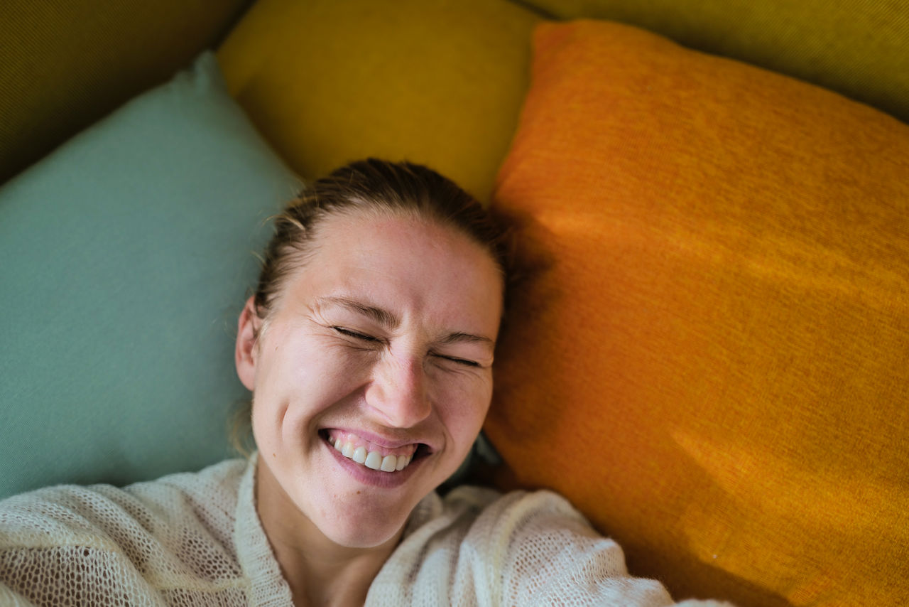 Woman relaxing on the colorful pillows smiling