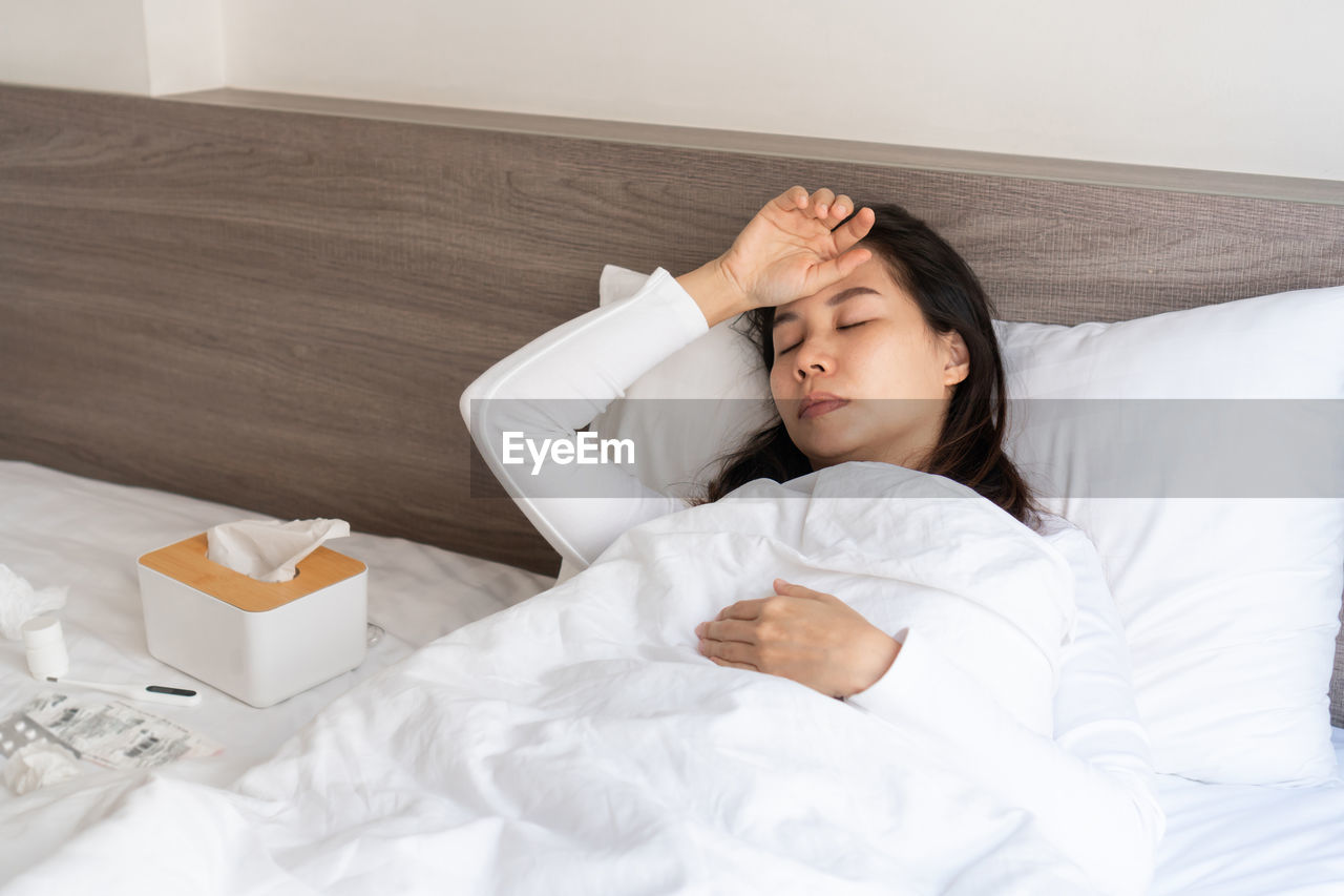 portrait of young woman sleeping on bed at home