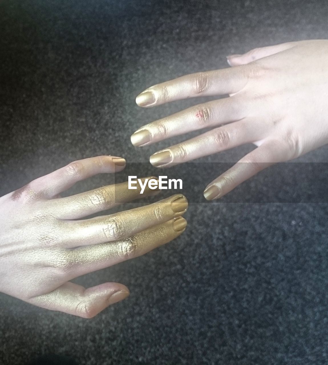 Cropped hands painted in gold color