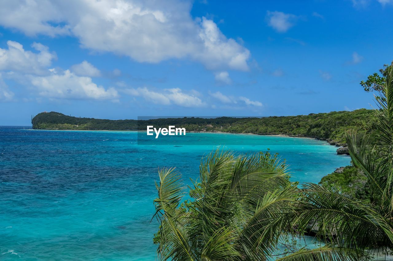 Scenic view of turquoise sea against blue sky