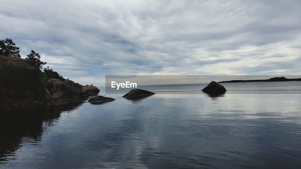water, sky, sea, reflection, cloud, scenics - nature, beauty in nature, coast, nature, land, tranquility, body of water, bay, ocean, shore, beach, rock, tranquil scene, landscape, environment, horizon, no people, outdoors, travel destinations, seascape, island, travel, coastline, wave, day, idyllic, non-urban scene, mountain, dusk, sunset, holiday, terrain