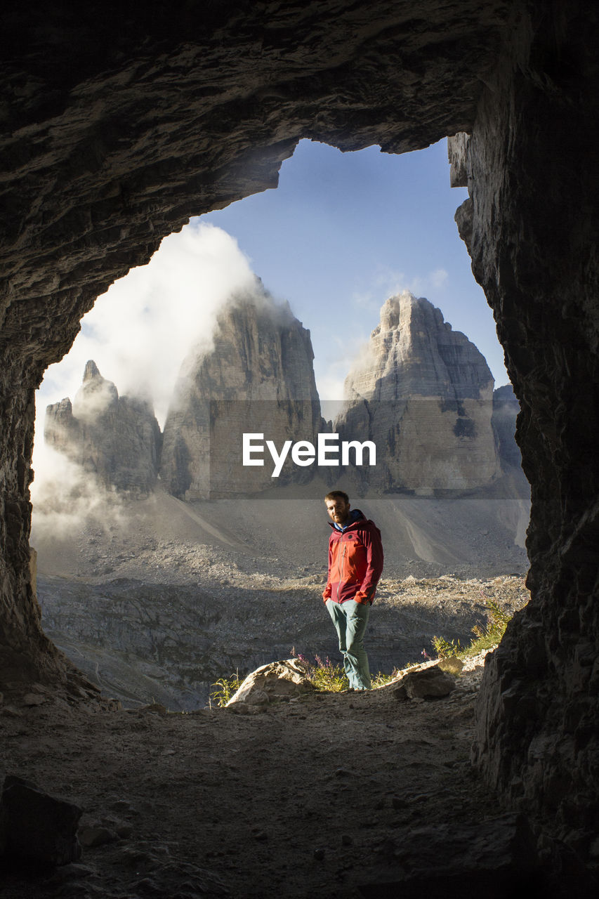 MAN STANDING ON ROCK FORMATIONS