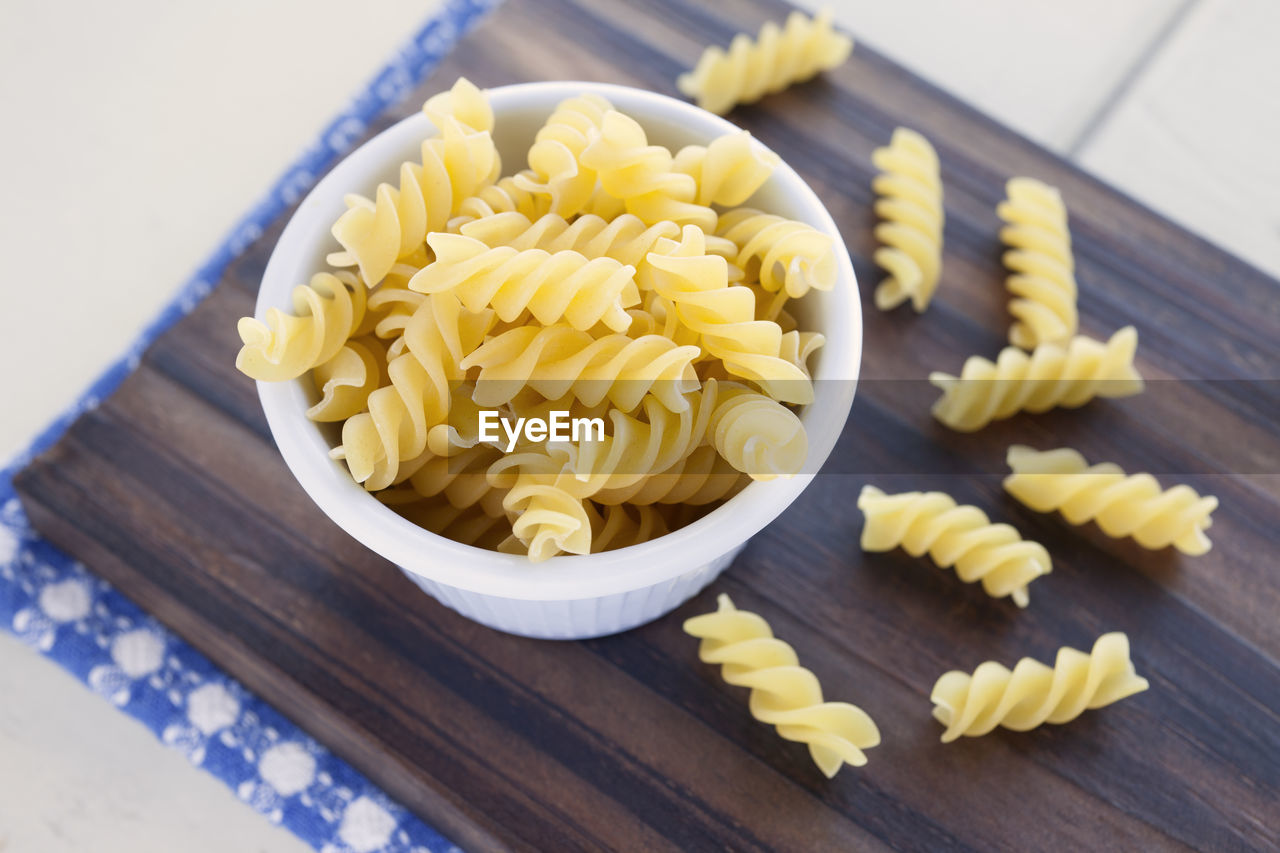 Close-up of pasta in bowl on cutting board