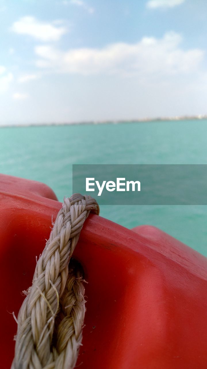 CLOSE-UP OF ROPE TIED TO BOAT