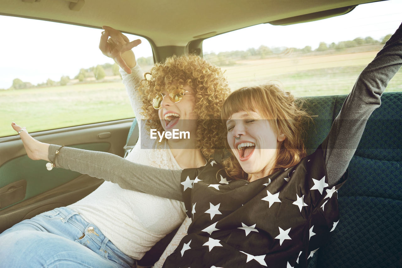 Cheerful female friends sitting in car