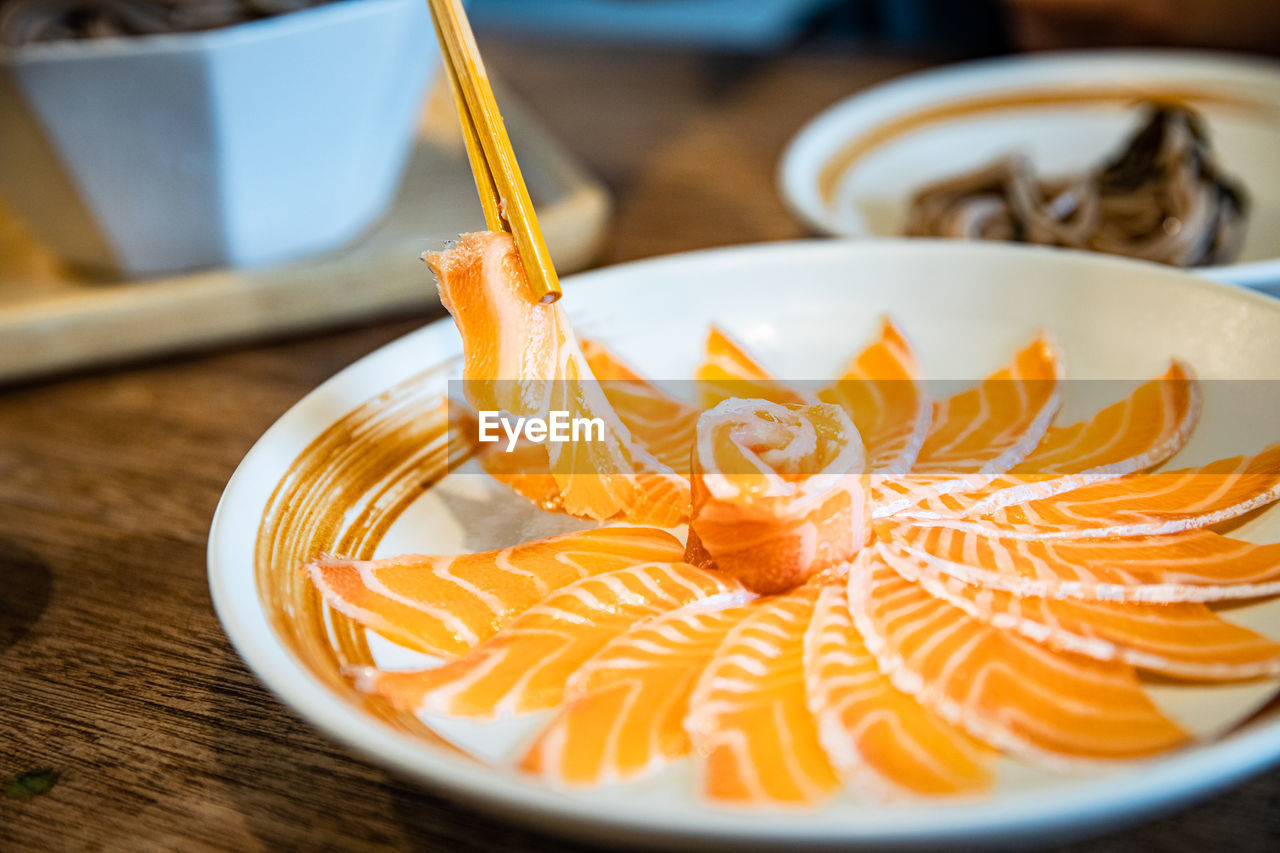 HIGH ANGLE VIEW OF ORANGE SLICE IN PLATE