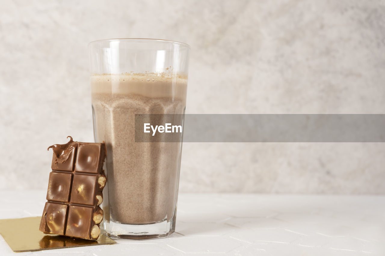 Delicious homemade cocoa drink with cocoa powder and pieces of chocolate bar. copy space.