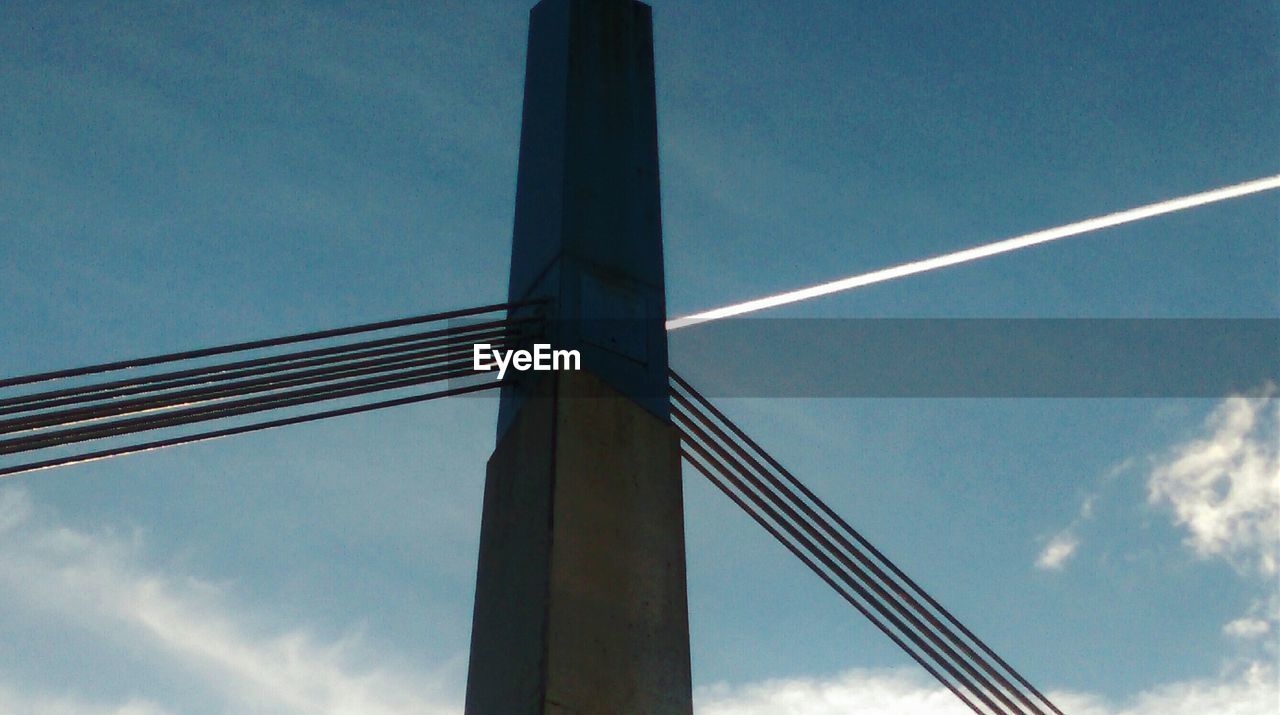 Low angle view of suspension bridge against blue sky