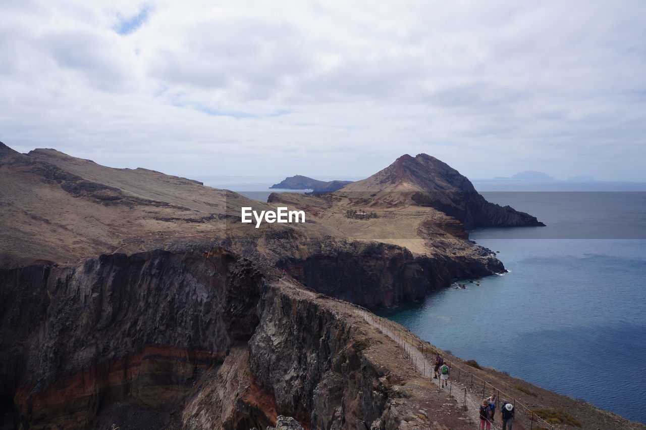 Scenic view of sea and mountains against sky