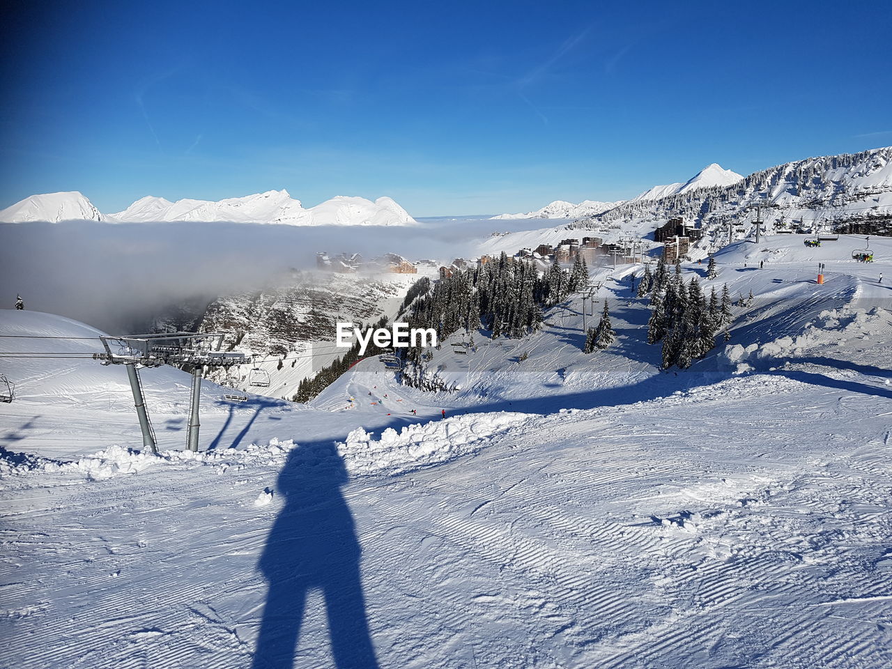 SHADOW OF PERSON ON SNOW COVERED MOUNTAIN