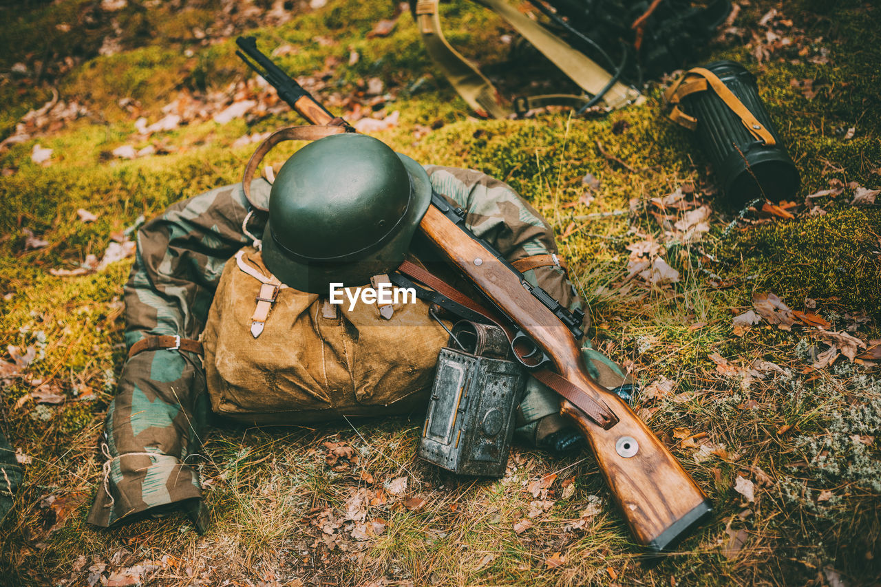 Military uniform and weapon on land in forest