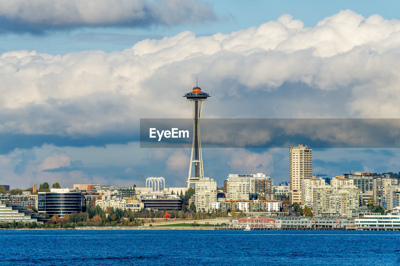 Architecture of the seattle skyline with elliott bay in front and clouds above.