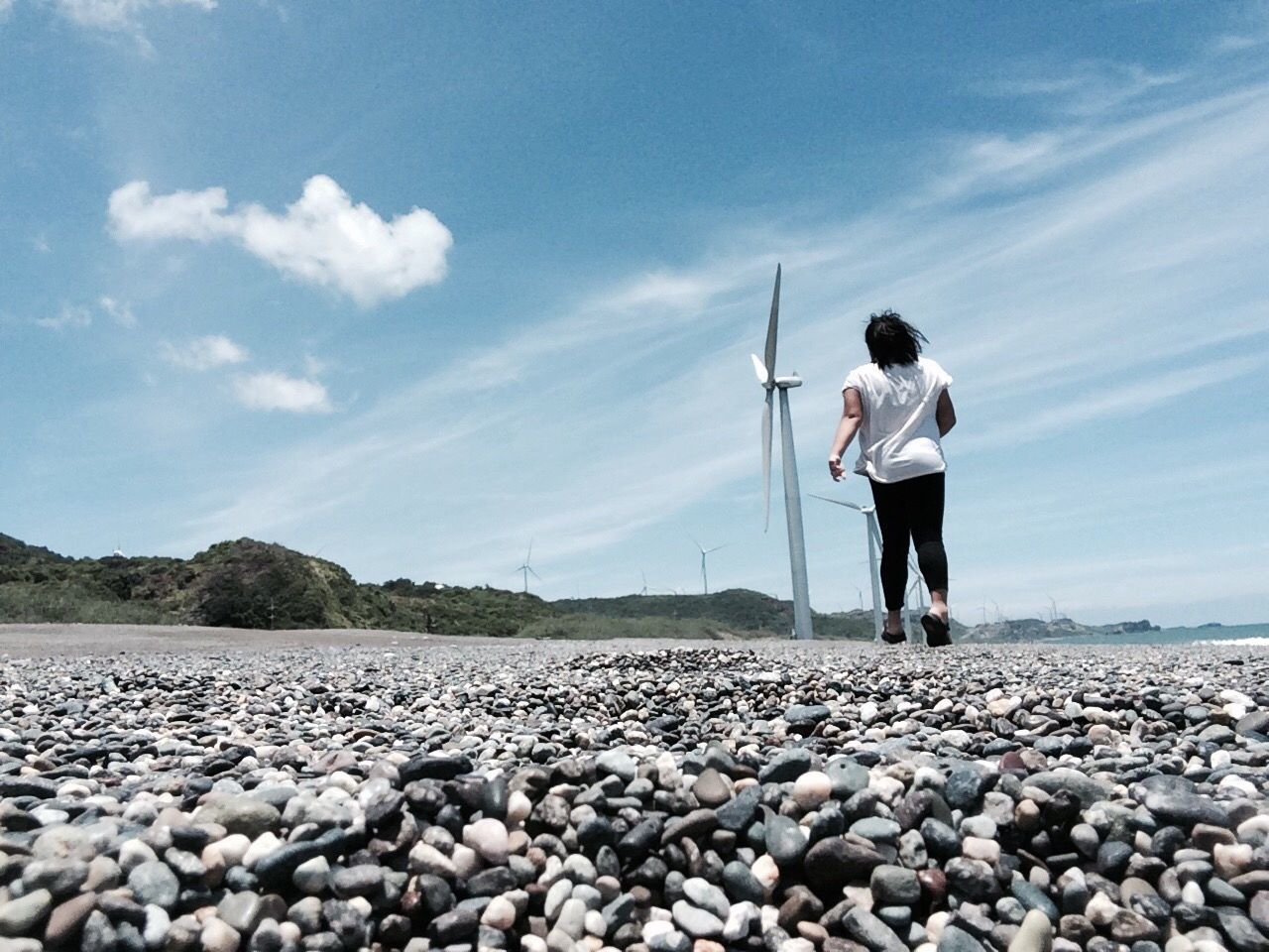 FULL LENGTH OF MAN STANDING ON PEBBLES IN SKY