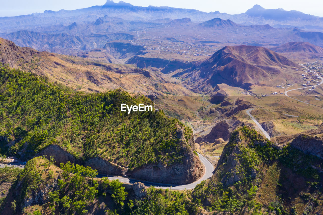Aerial view of road amidst trees and mountains