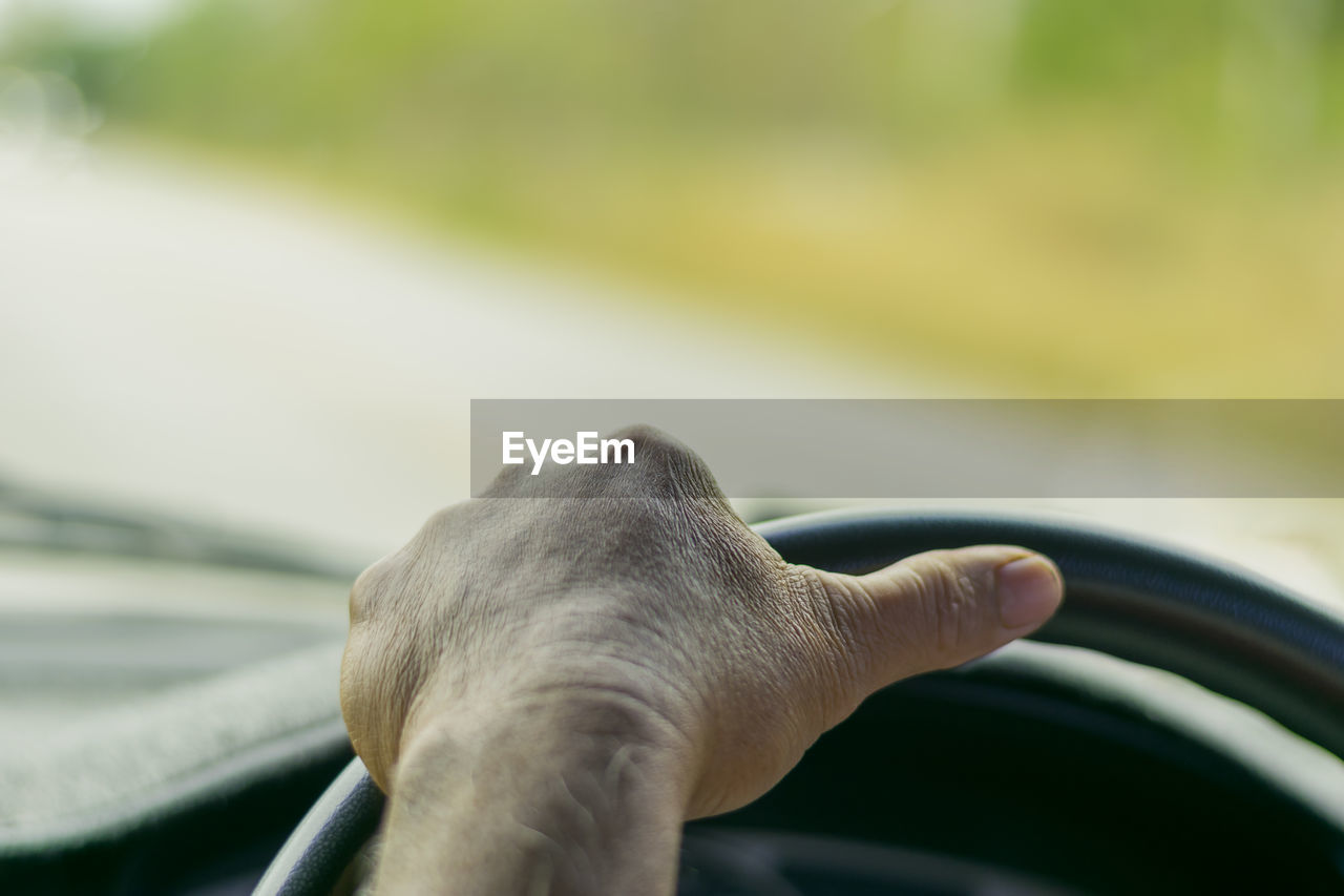 Close-up of person hand driving car