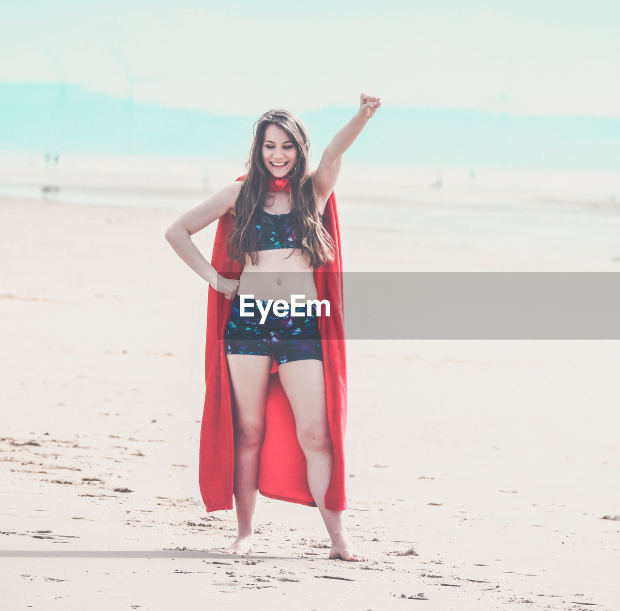 PORTRAIT OF BEAUTIFUL YOUNG WOMAN STANDING ON BEACH