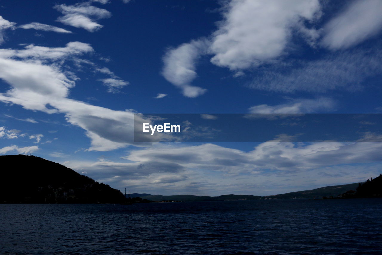 SCENIC VIEW OF SEA BY MOUNTAINS AGAINST SKY