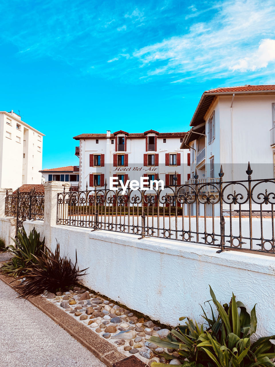 architecture, building exterior, built structure, building, estate, sky, nature, vacation, house, residential district, city, home, no people, facade, blue, plant, residential area, cloud, outdoors, travel destinations, tropical climate, street, water, day, mansion, travel, railing, neighbourhood, palm tree