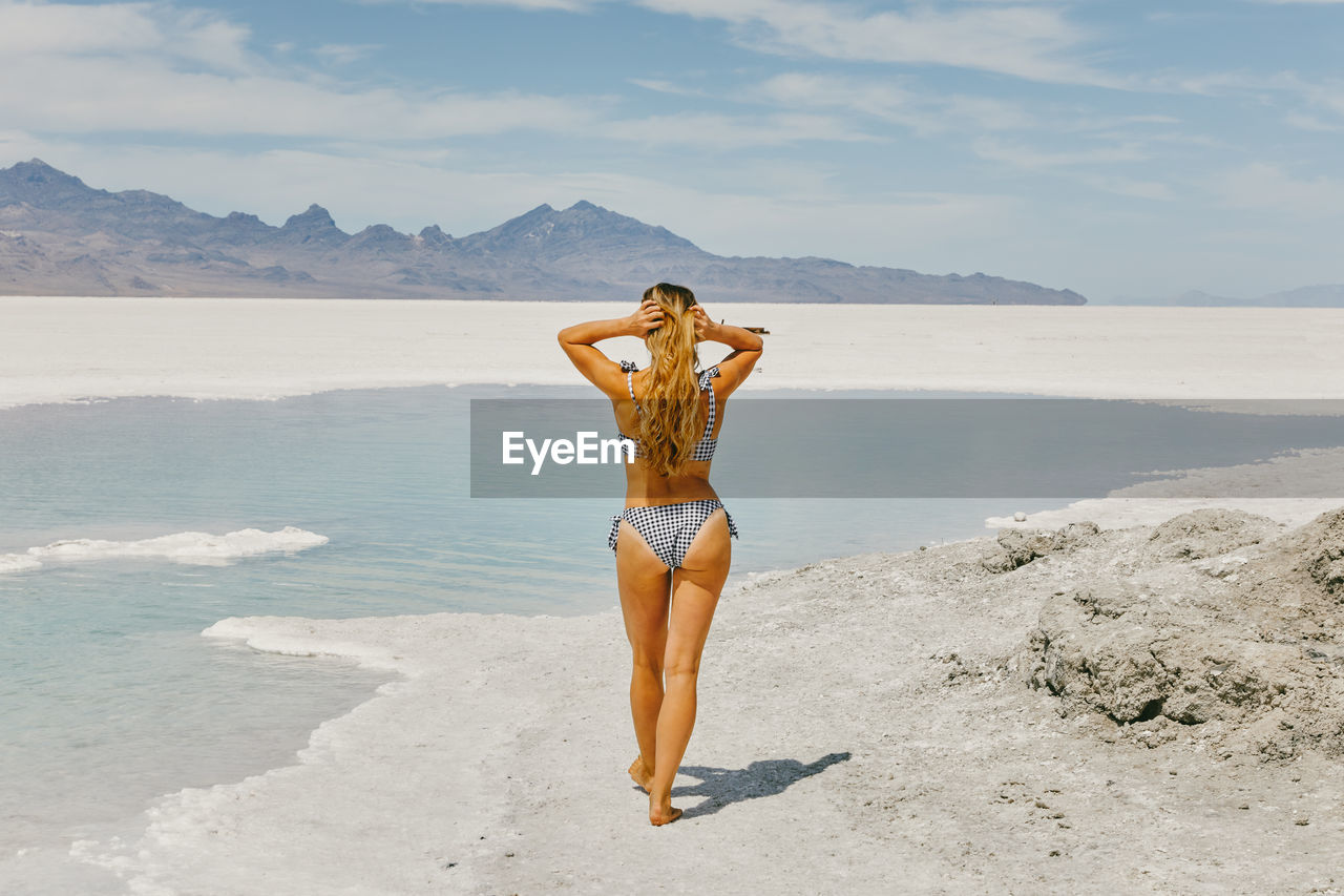 Young woman in bathing suit exploring the bonneville salt flats.