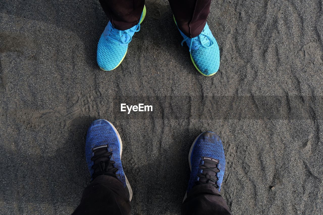 Low section of people standing on sand