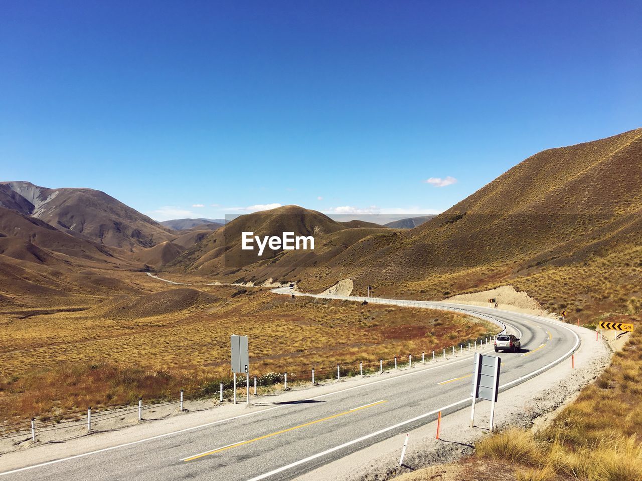 ROAD BY MOUNTAIN AGAINST BLUE SKY