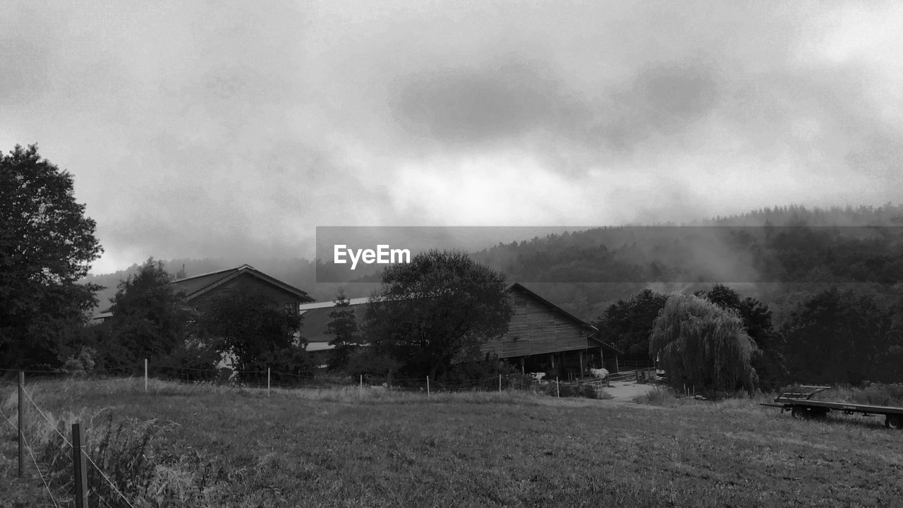 HOUSE ON FIELD AGAINST SKY