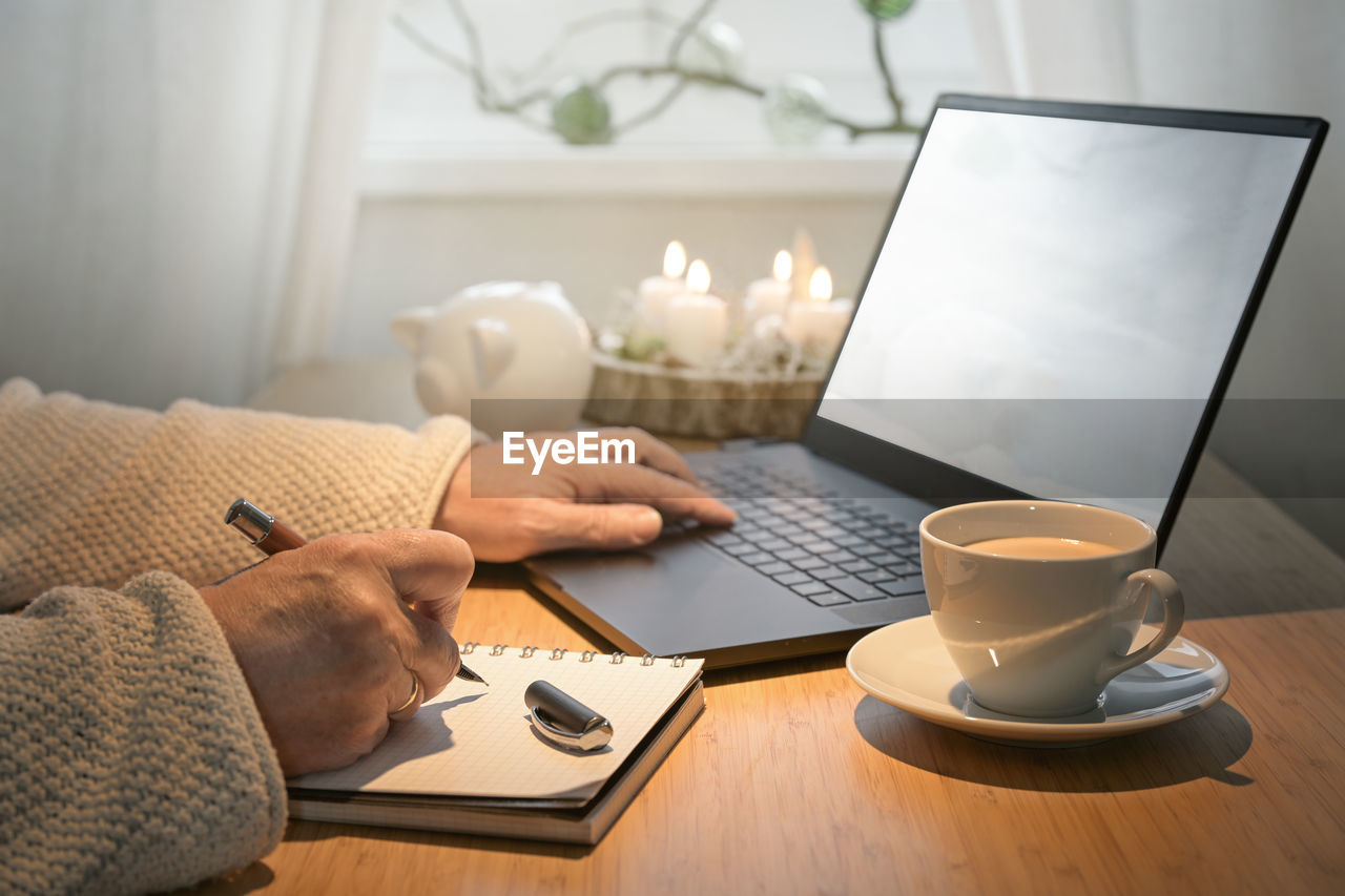 midsection of woman using laptop at table