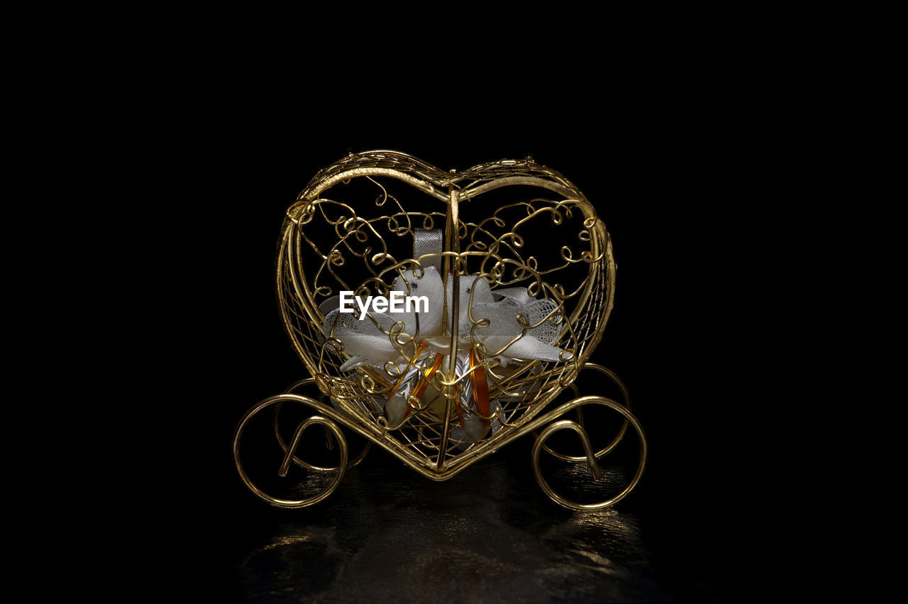 Heart shape golden decoration against black background