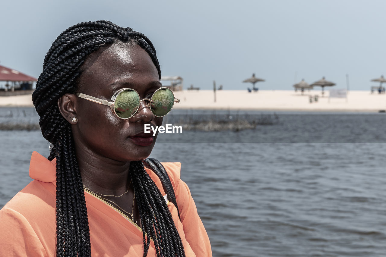 Africa woman with sunglasses from ghana enjoying the sun on a beach in accra.