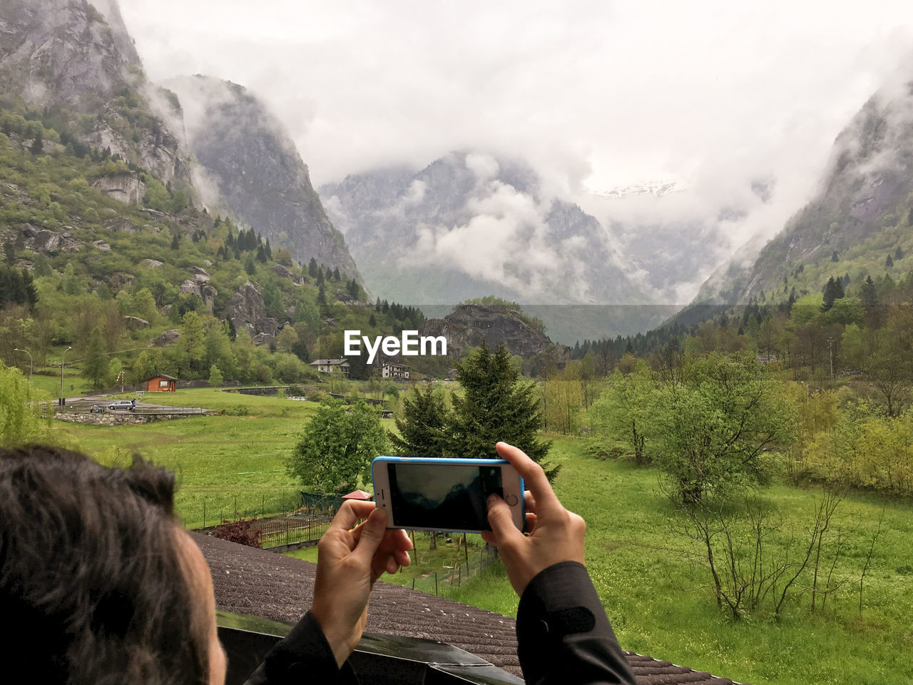 Cropped image of man photographing field and mountains