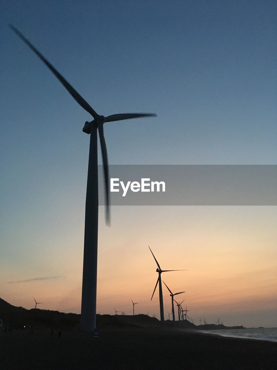 LOW ANGLE VIEW OF WINDMILLS AGAINST SKY