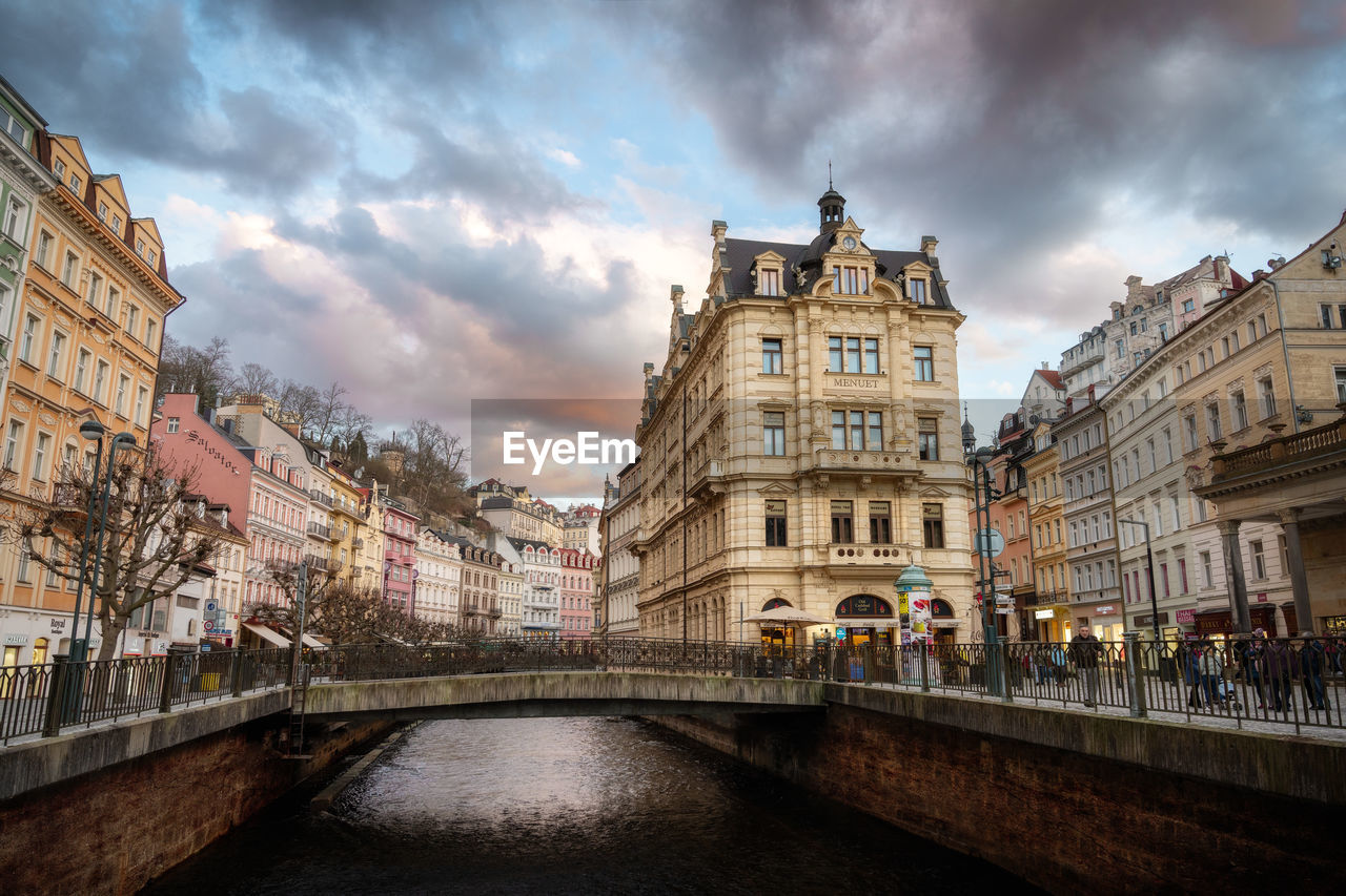 architecture, cityscape, built structure, building exterior, landmark, city, travel destinations, cloud, sky, waterway, urban area, nature, canal, water, town, travel, bridge, evening, building, tourism, history, reflection, the past, street, transportation, city life, tower, outdoors, sunset, dusk, old, holiday, town square, downtown