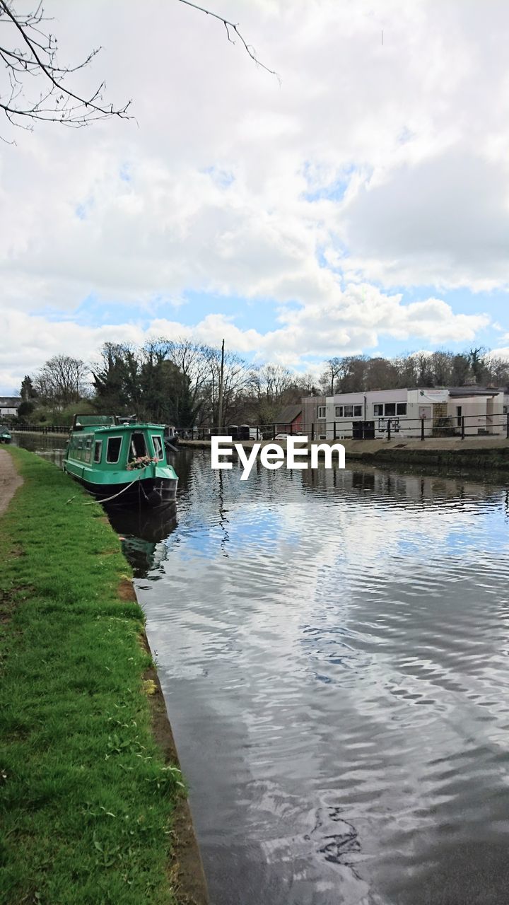 BOATS MOORED BY LAKE AGAINST SKY