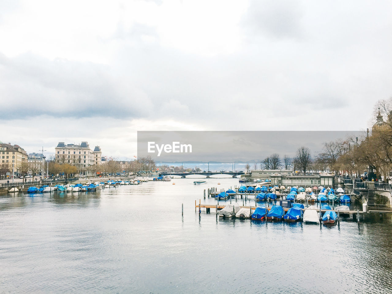 Boats moored at harbor against sky