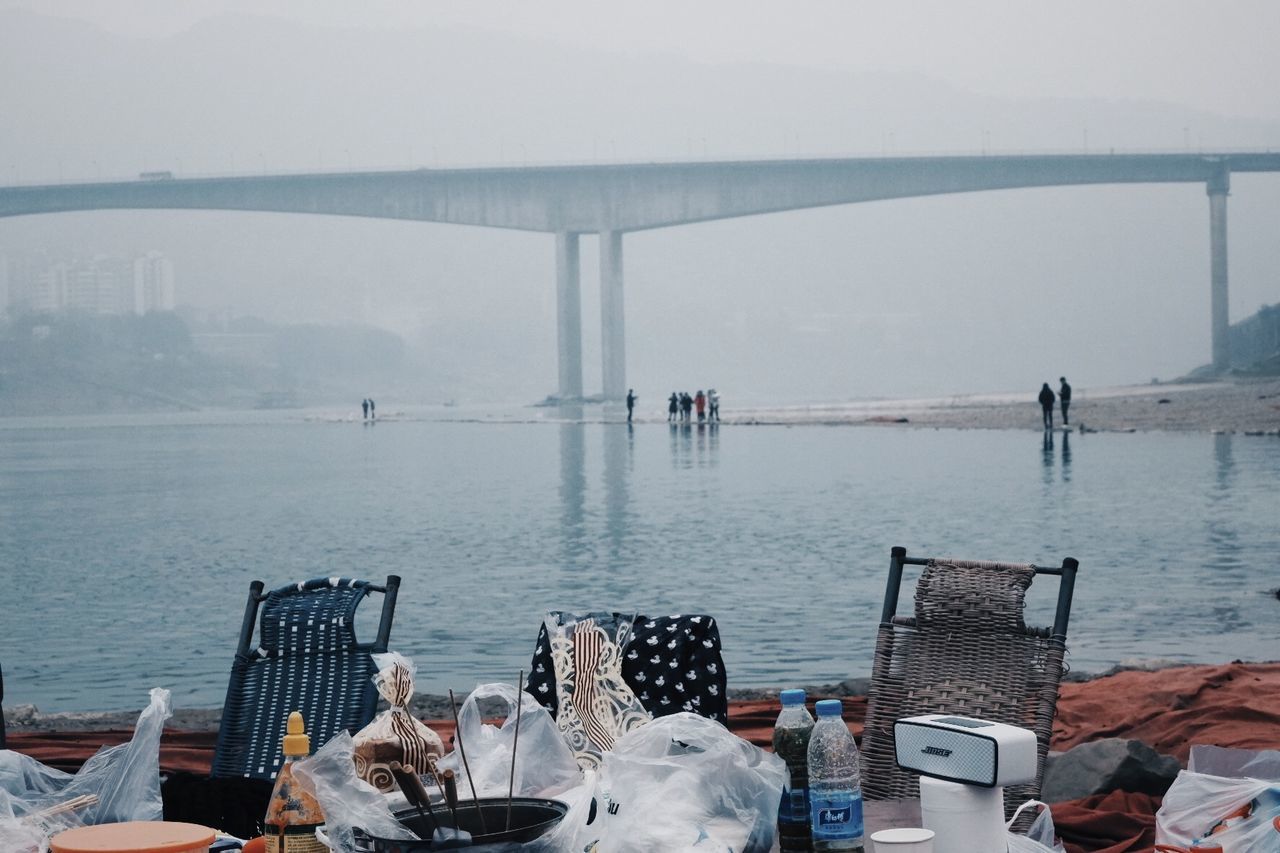 GROUP OF PEOPLE ON BRIDGE OVER SEA