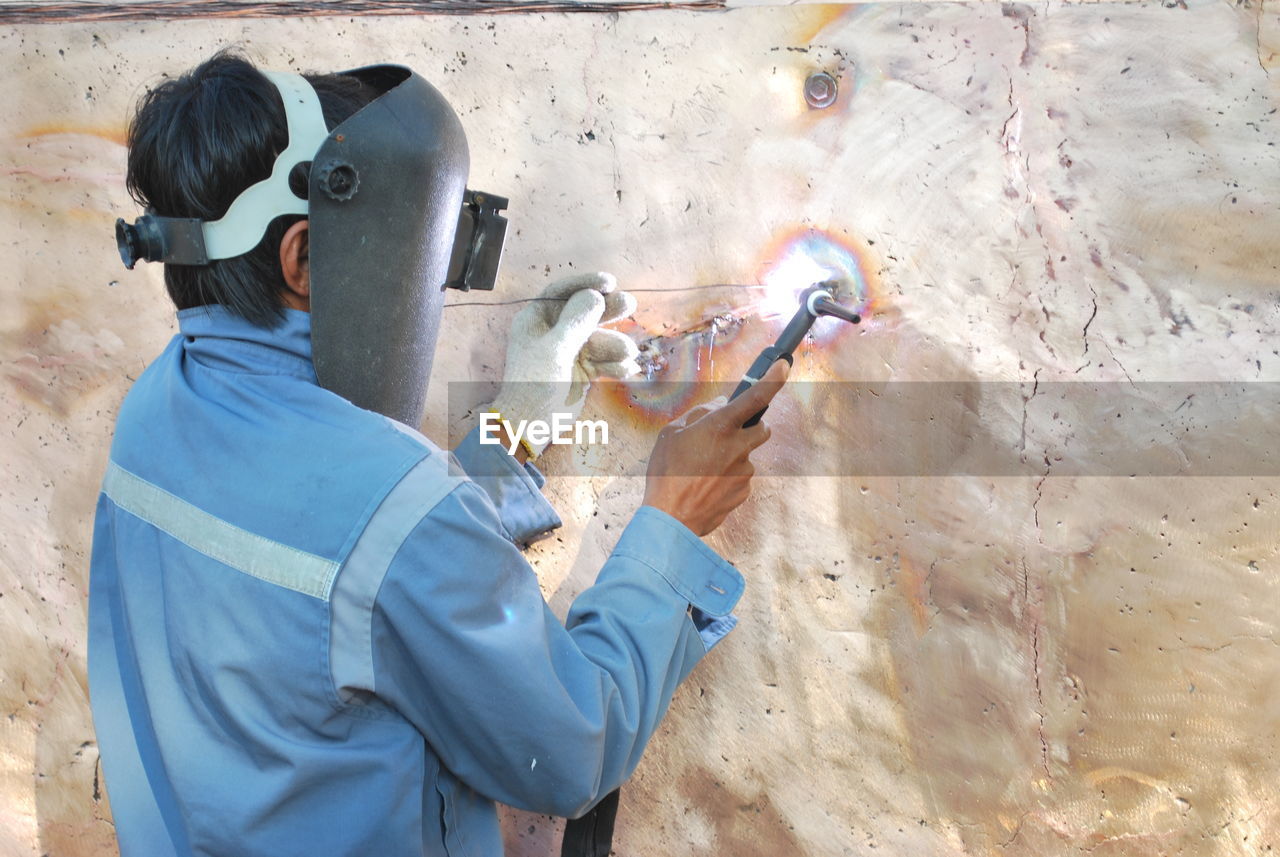 MAN WORKING WITH ARMS OUTSTRETCHED