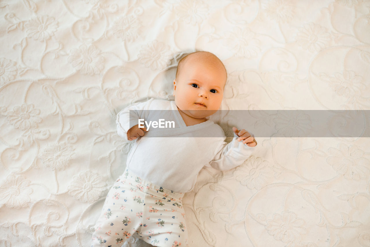 Cute baby girl lying on bed