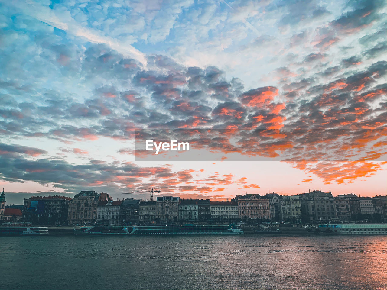 SEA AND BUILDINGS AGAINST SKY DURING SUNSET