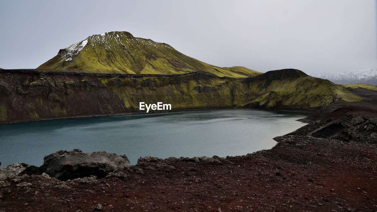 Scenic view of sea and mountains against clear sky