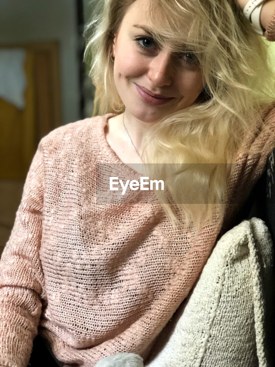 Portrait of smiling young woman sitting at home