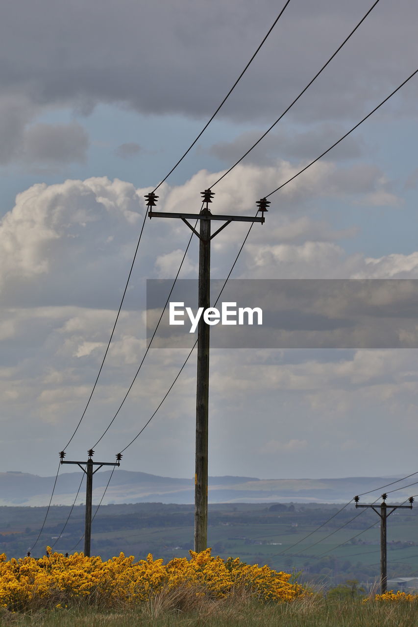 Electricity pylon on field against sky